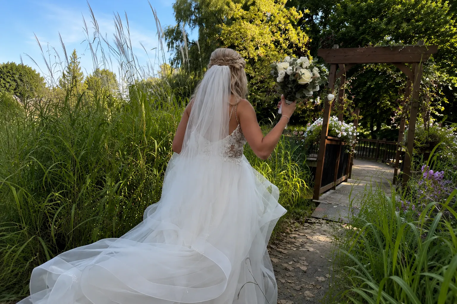 Mariée coiffée et voilée par l'équipe du Studio Délia, dans un jardin